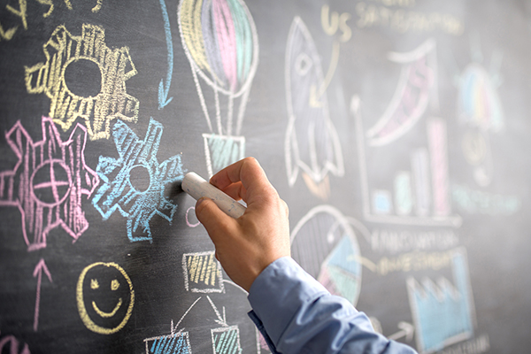 businessman illustrating on blackboard the strategy for success