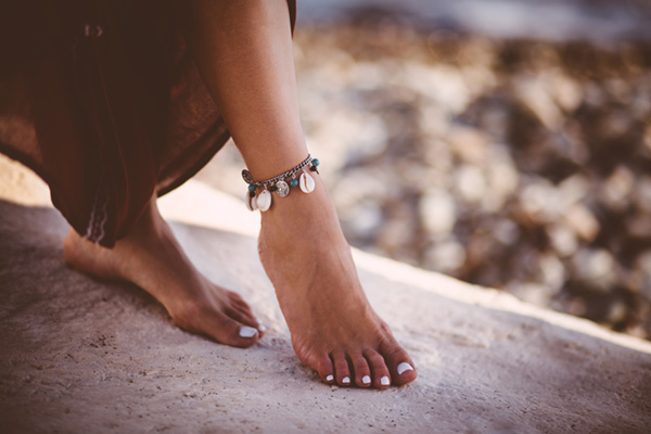 young woman in boho style wearing silver ankle bracelet