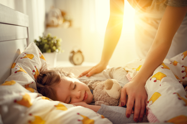 mother wakes up sleeping child daughter girl in morning