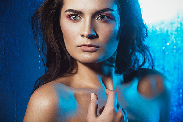 Beauty portrait of beautiful female model on a blue background.