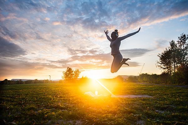 Happy young woman jumping in park